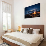 Bedroom with a large bed and a wall art of a beach scene with a fire.
