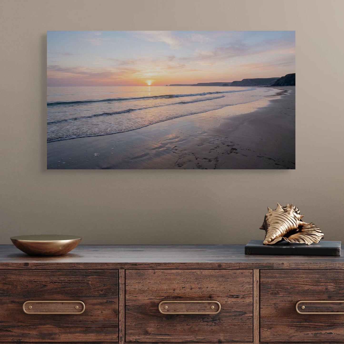 Beach scene painting above a wooden console table with decorative items.