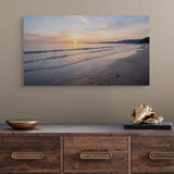 Beach scene painting above a wooden console table with decorative items.