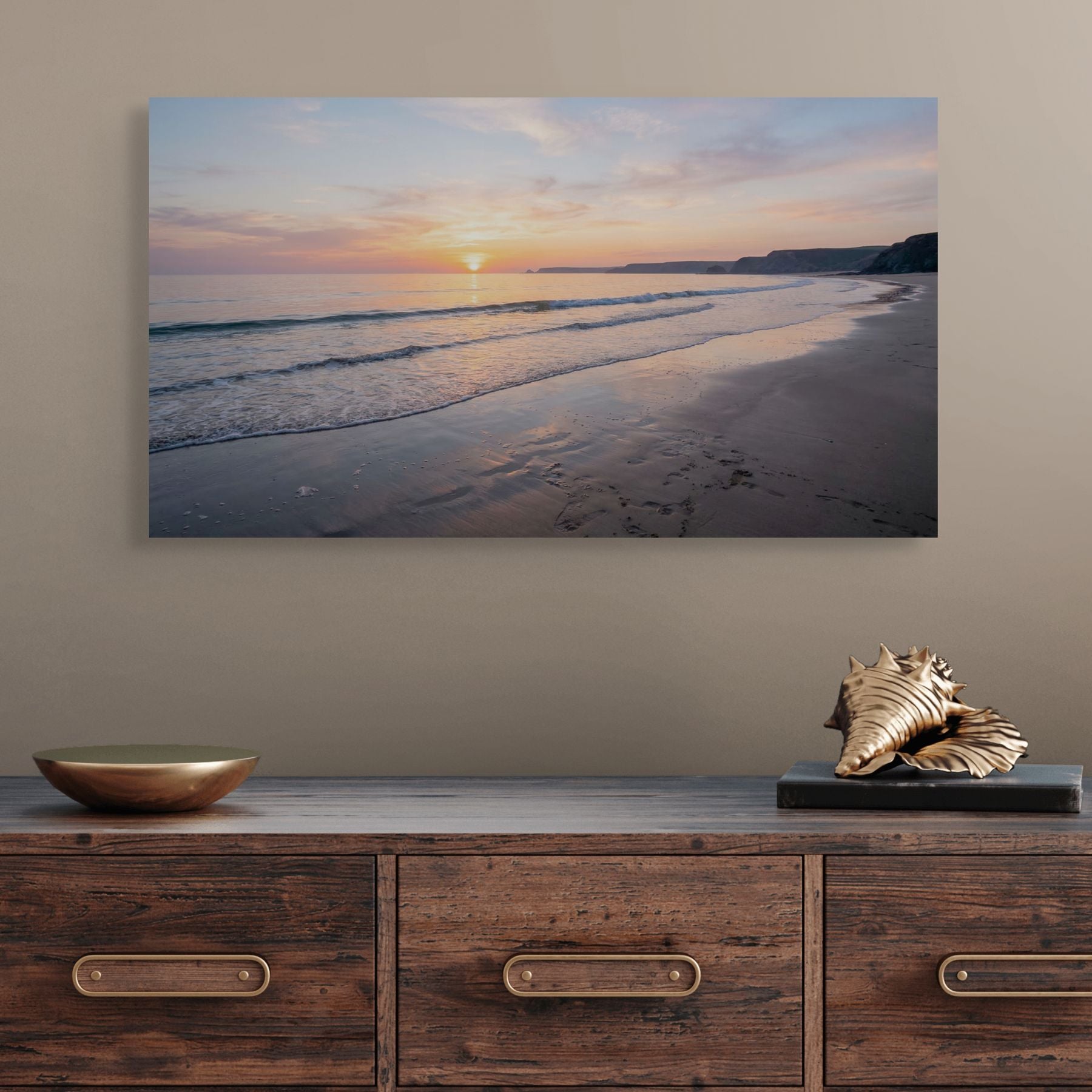 Beach scene painting above a wooden console table with decorative items.