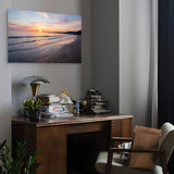 Home office with a desk, chair, and wall art of a beach sunset.
