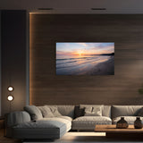 Modern living room with a large TV displaying a beach sunset, a gray sectional sofa, and decorative vases on a wooden coffee table.