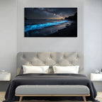 Bedroom with a large canvas print of a beach scene with glowing blue water on the wall.