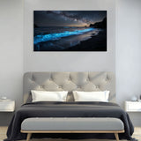 Bedroom with a large canvas print of a beach scene with glowing blue water on the wall.