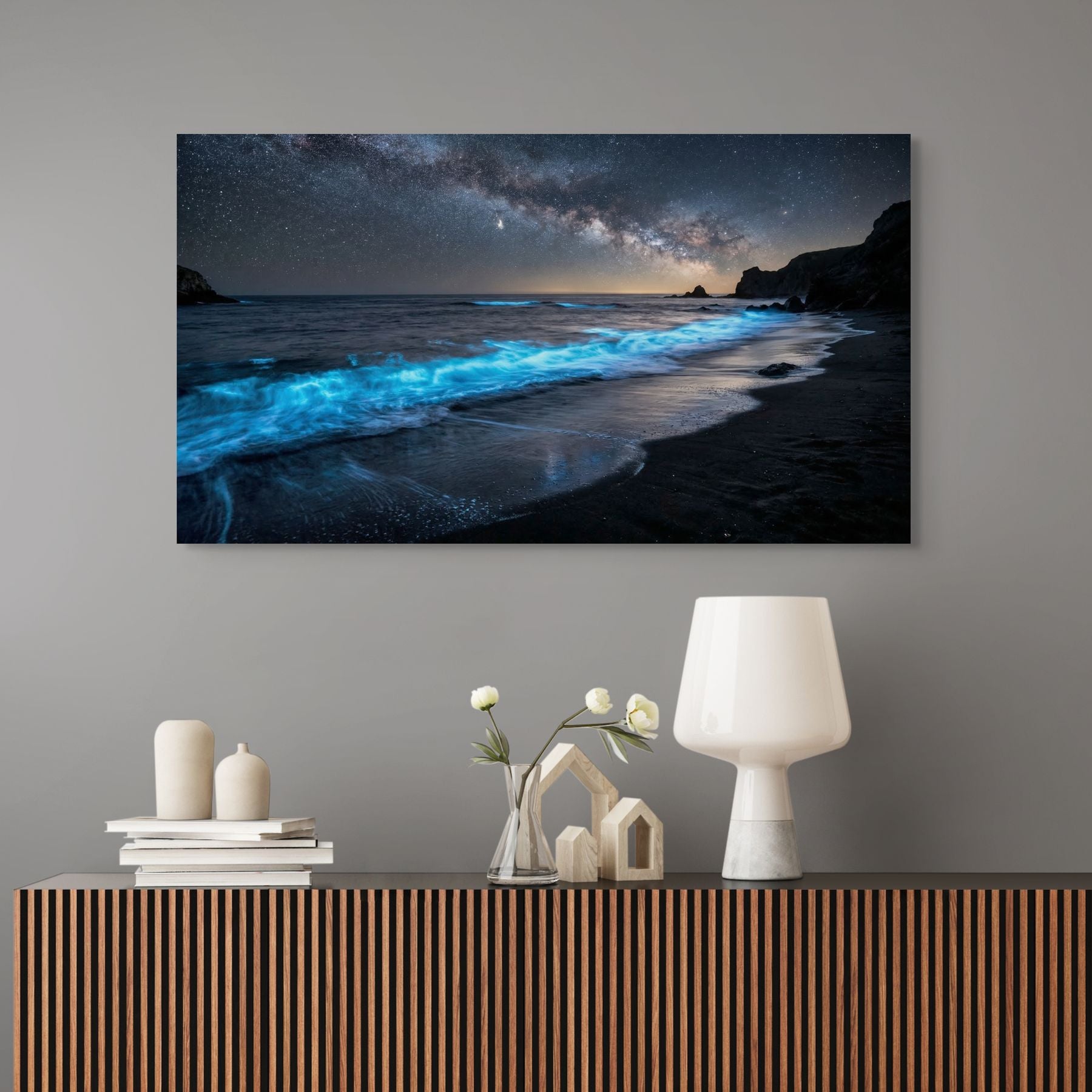 Wall art of a starry night beach scene above a console table with decorative items.