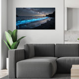 Modern living room with a gray sofa and a large wall-mounted canvas displaying a beach scene.
