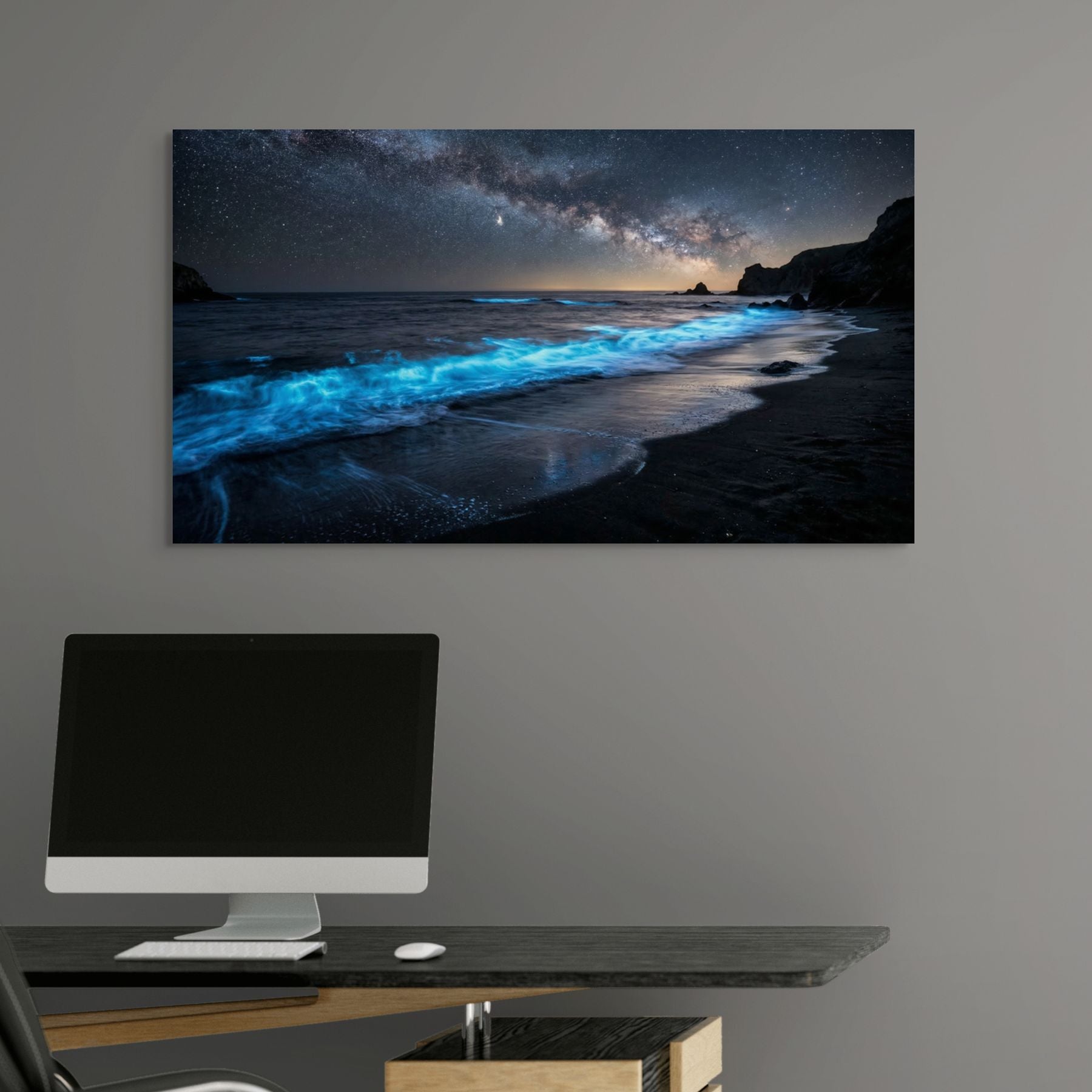 Wall-mounted computer setup with a large canvas print of a beach scene with glowing blue water.