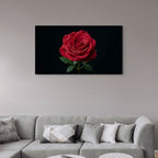 Red rose painting on a wall above a gray sofa with decorative pillows.