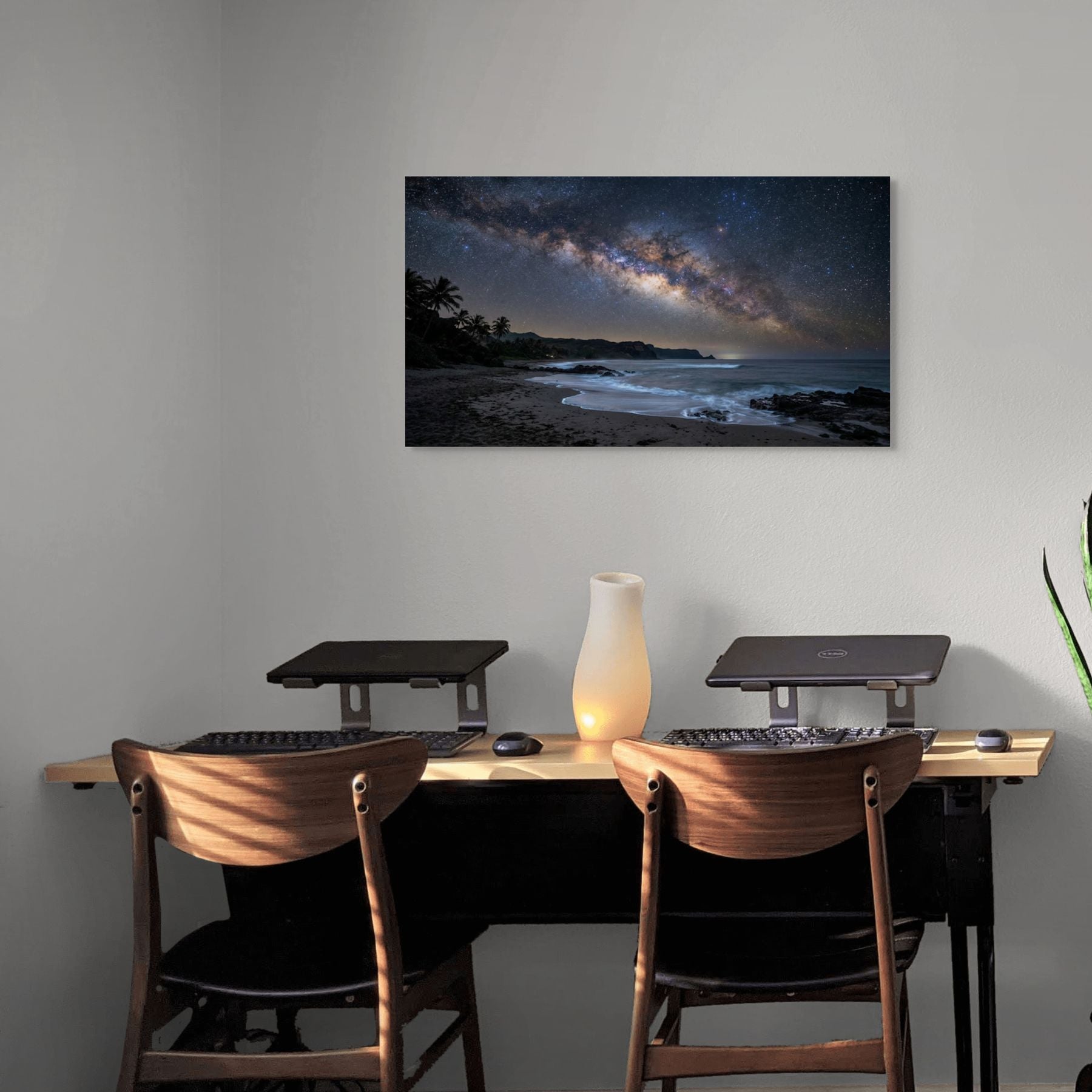 Modern office setup with a desk, chairs, and a large wall-mounted canvas of a beach scene.