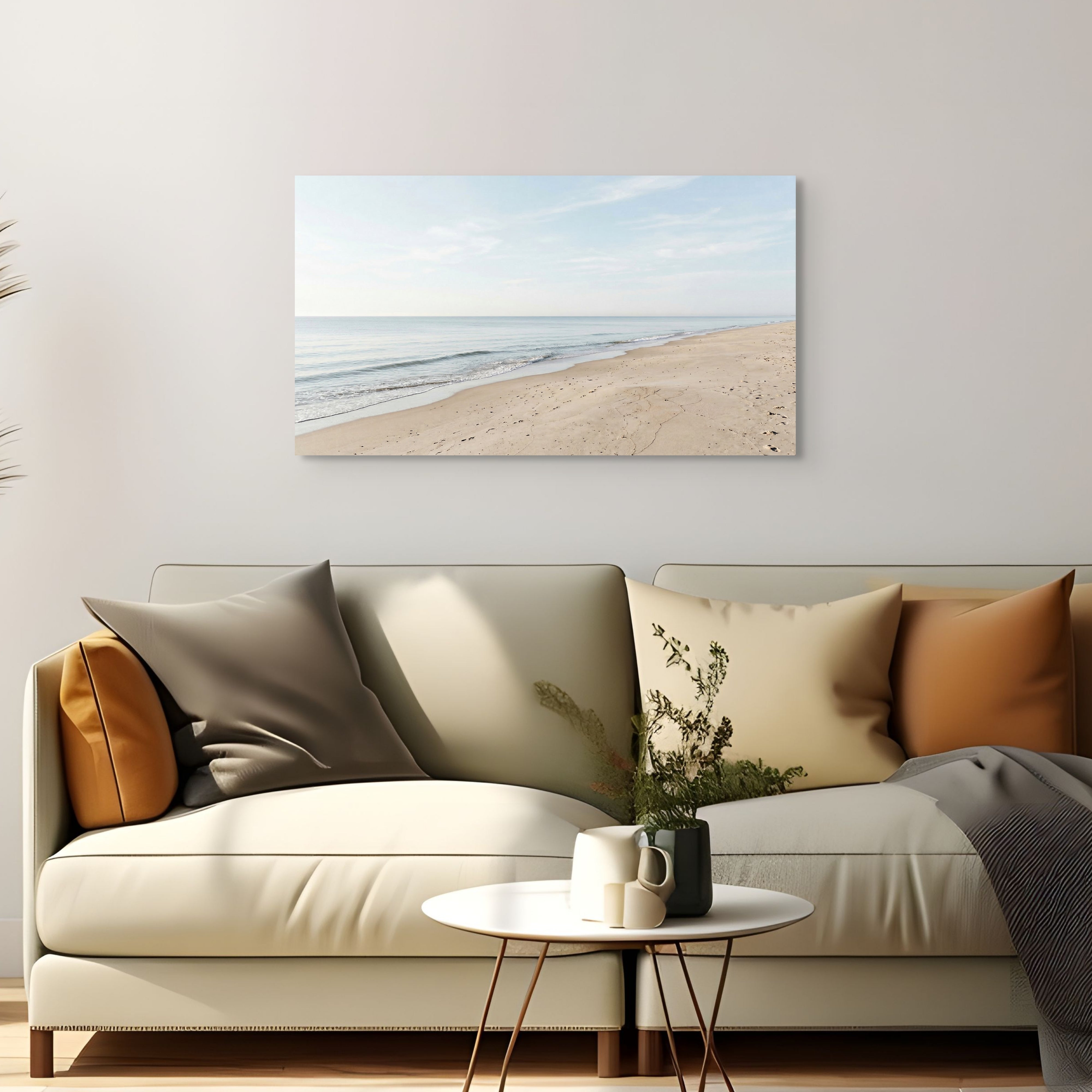Beige sofa with decorative pillows and a small table in a living room, featuring a beach scene painting on the wall. Main image