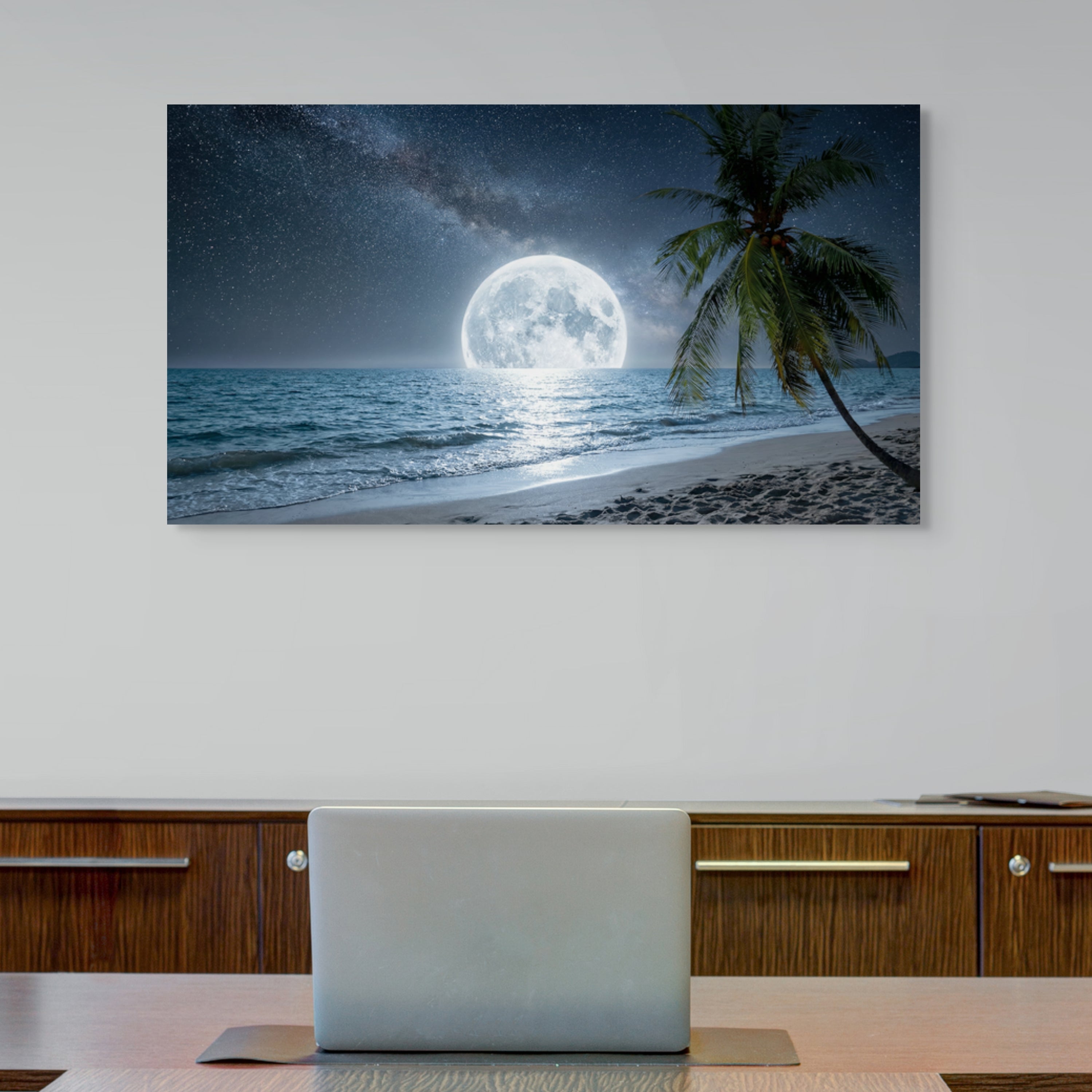 Beach scene with palm tree and full moon on a wall above a desk.
