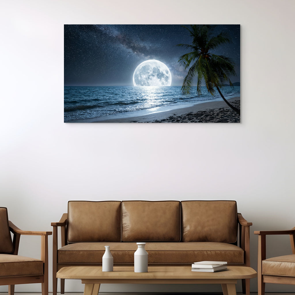 Beach scene with moonlit sky and palm tree on wall above brown sofa.