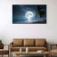 Beach scene with moonlit sky and palm tree on wall above brown sofa.
