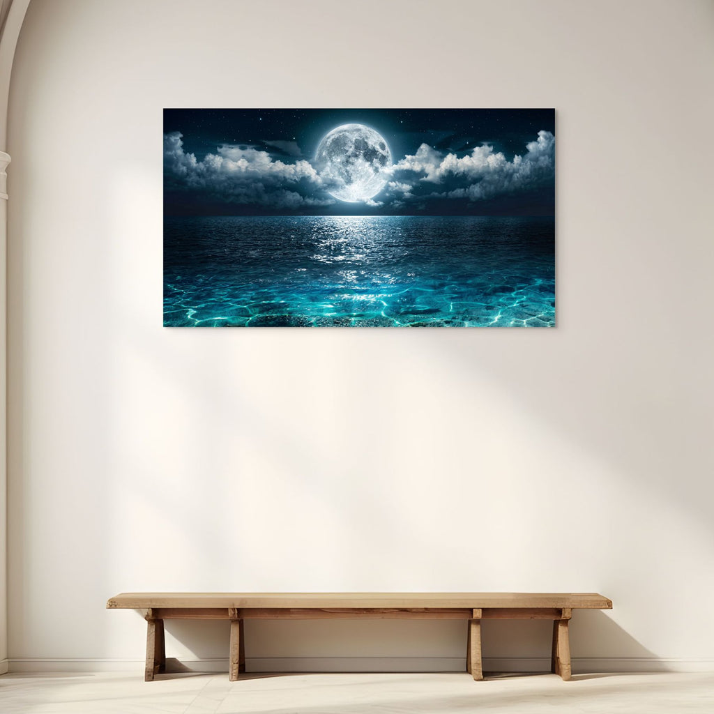 Wall art of a moonlit sea above a wooden bench in a minimalistic room.