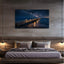 Bedroom with a large wall-mounted canvas displaying a night scene of a pier over water.