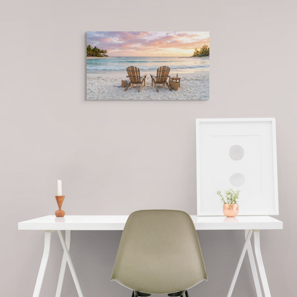 Beach scene painting above a desk with a chair and decorative items.