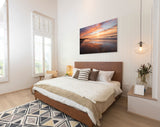 Modern bedroom with wooden bed, decorative pillows, and a sunset painting on the wall.