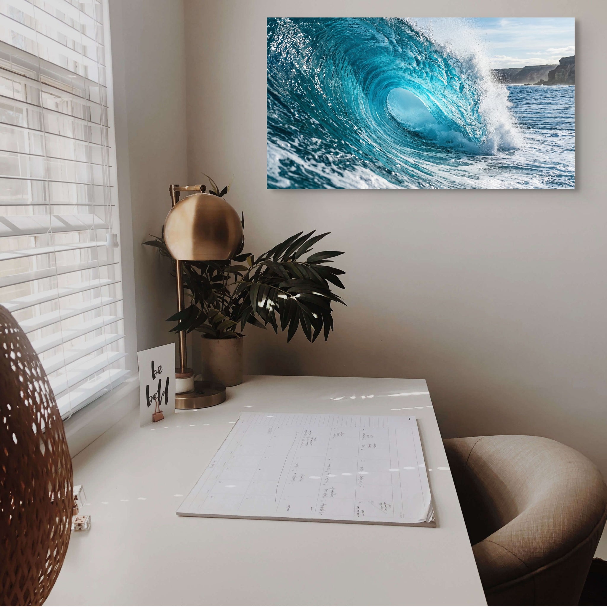 Home office with a desk, chair, and wall art of a wave.