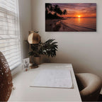 Home office with a desk, plant, and wall art of a sunset over water.