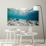 Underwater scene wall art in a modern interior setting with white tables and decor.